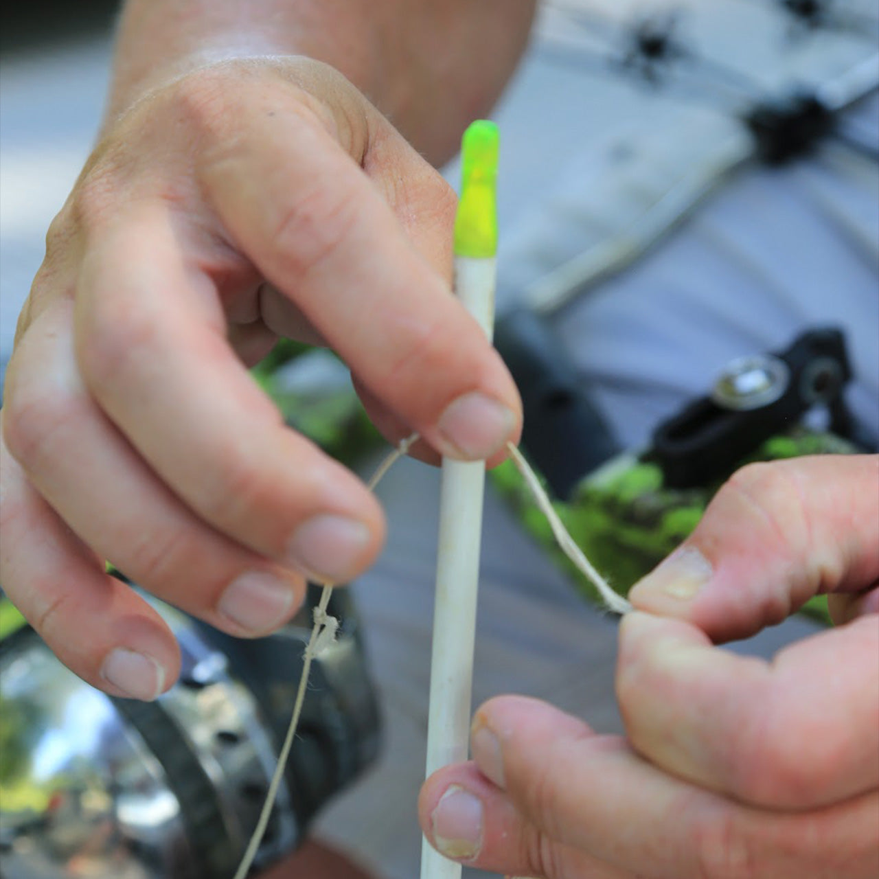 Small archery target pin being set with string for bowhunting accuracy practice.