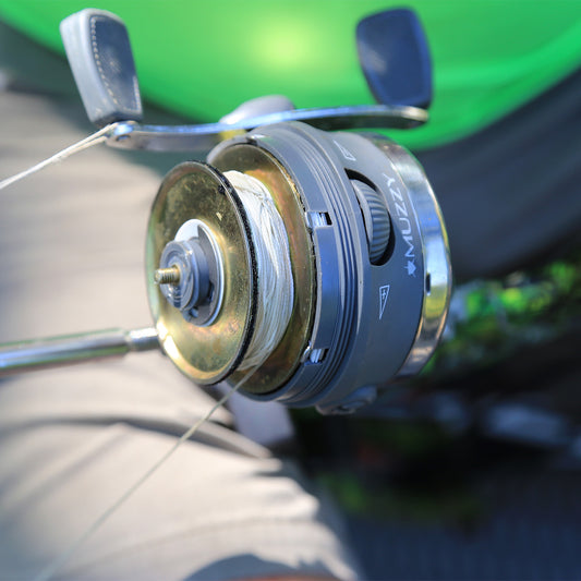 Anti-reverse fishing reel, close-up view for archery and bowhunting enthusiasts.
