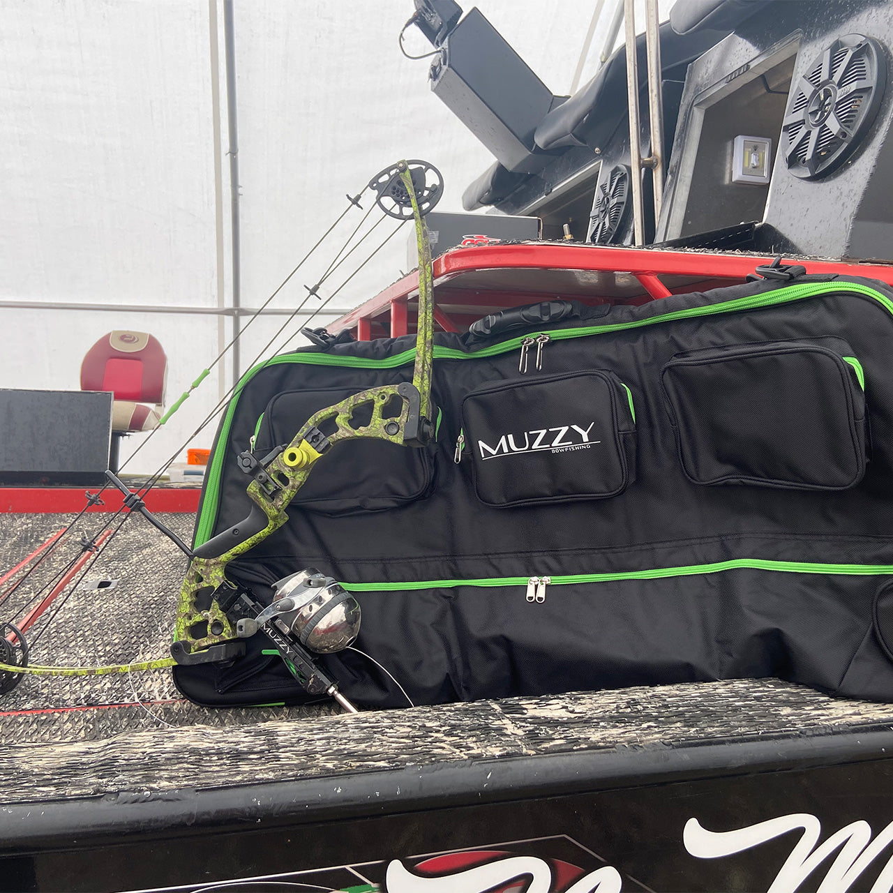 Bright green camouflage bow and black bowhunting gear bag on truck bed for outdoor archery.