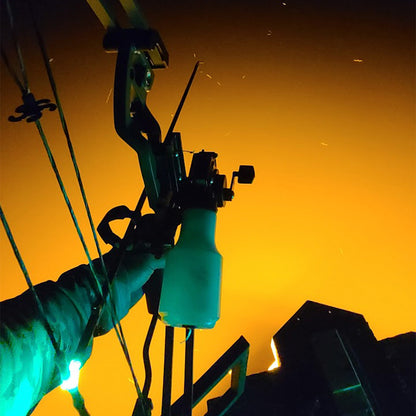 Brightly lit compound bow against sunset sky, ready for nighttime hunting.