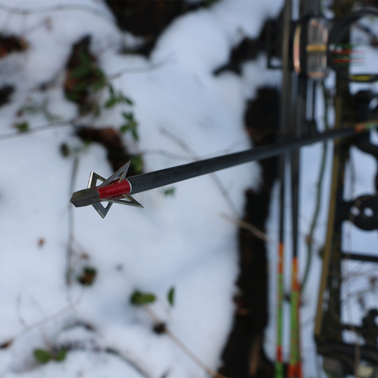 1. Durable archery broadhead arrow in snowy outdoor hunting setting.