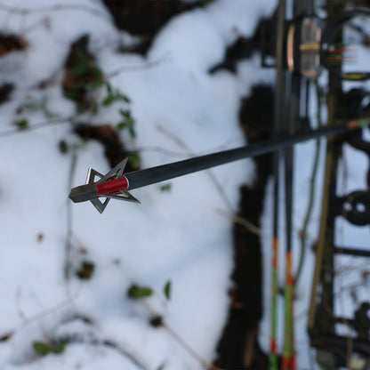 1. Durable archery broadhead arrow in snowy outdoor hunting setting.