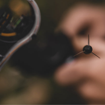 High-tech bowhunting sight being adjusted during an outdoor hunting trip.