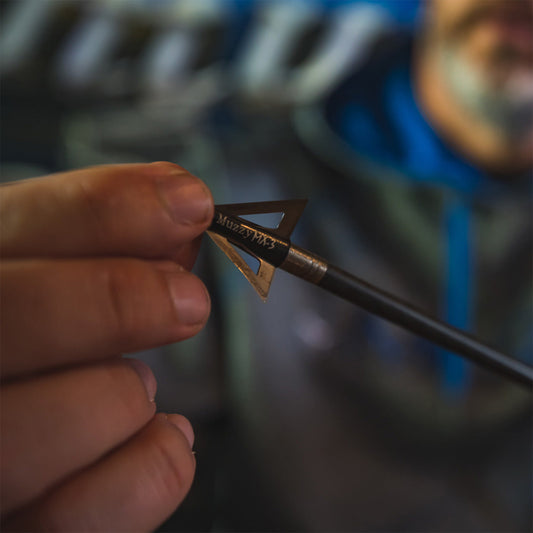 Precision archery arrow tip being inspected for accuracy and quality.