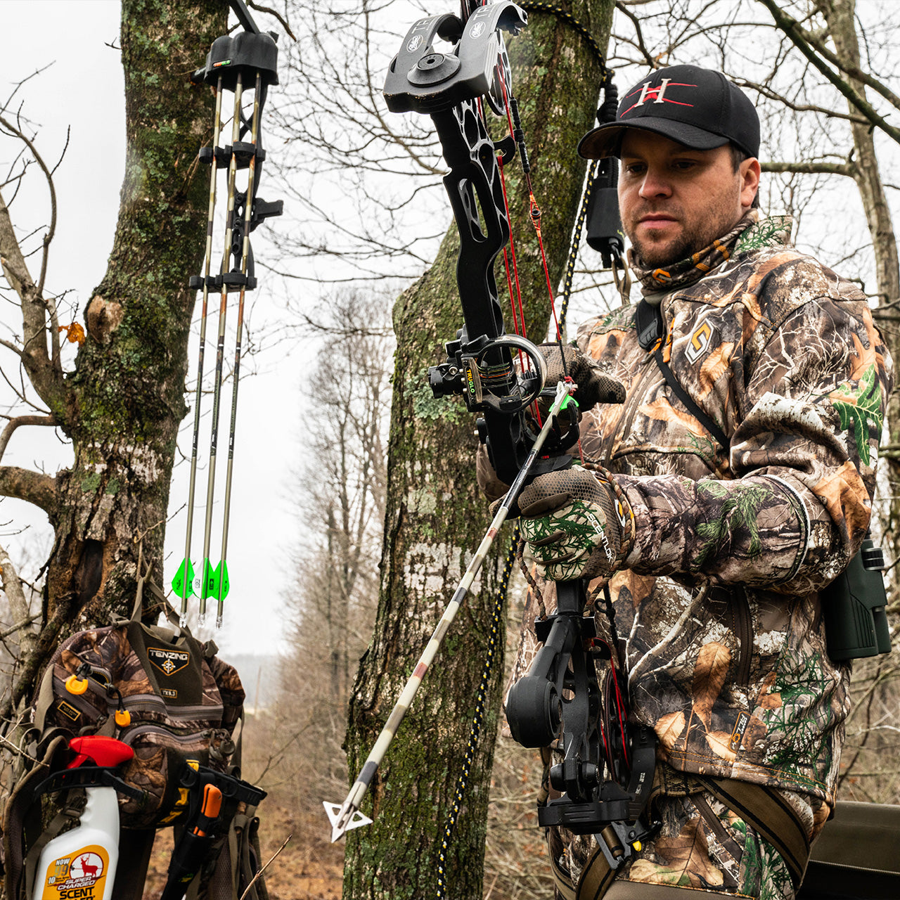 Camouflage bow hunting gear and archery equipment in forest setting for outdoor sports.