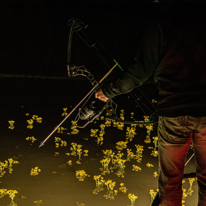 Quiet nighttime bowhunting scene with a person holding a modern compound bow.