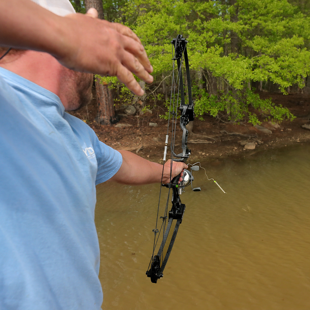 Precise archery shot over water using a high-quality compound bow outdoors. FeraDyne gear ensures accuracy in bowhunting.