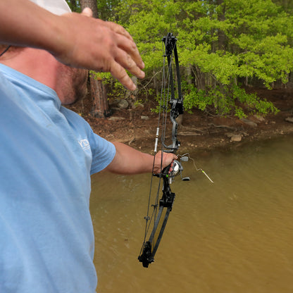Precise archery shot over water using a high-quality compound bow outdoors. FeraDyne gear ensures accuracy in bowhunting.