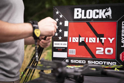 1. person adjusting a bow sight at an archery shooting range outdoors.