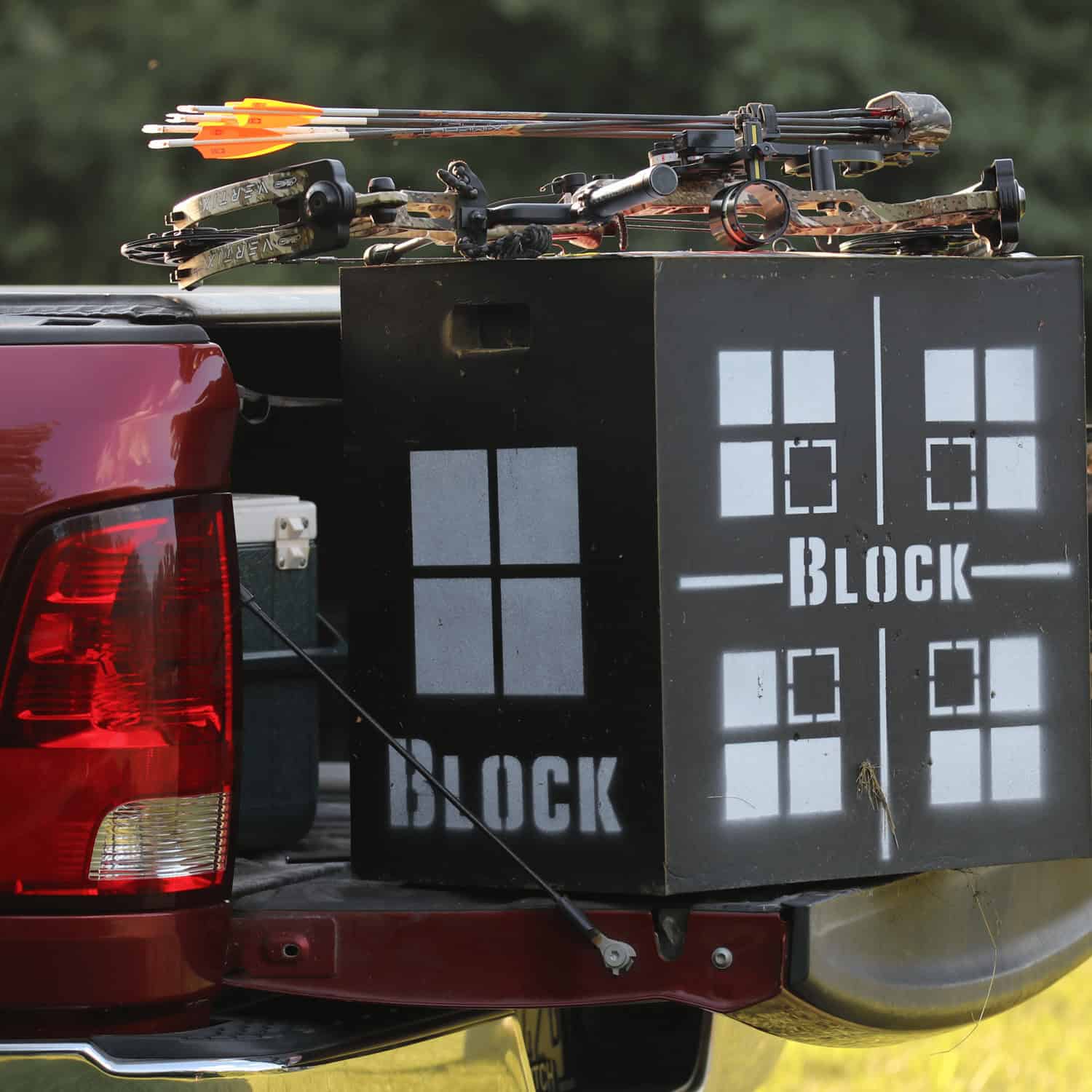 Crossbow and archery gear loaded in truck bed with a Block target for archery practice.