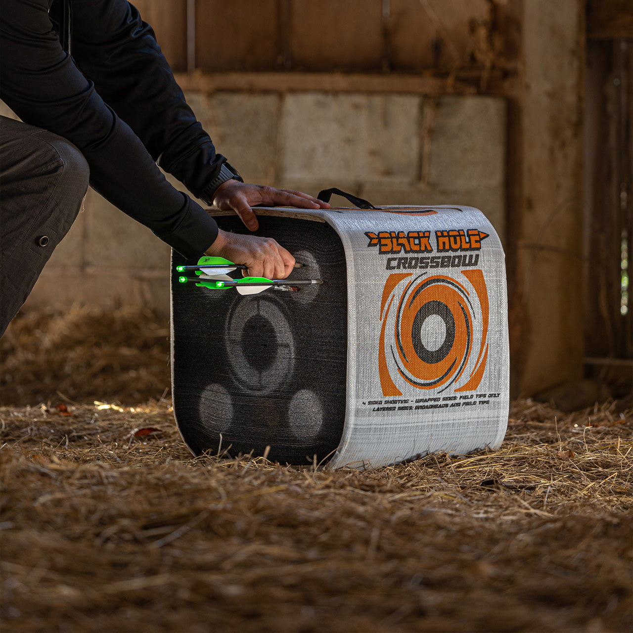 1. Archery target with illuminated arrows set inside a barn for indoor practice.