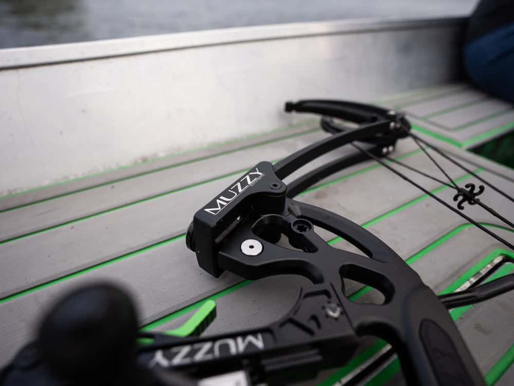 High-performance bow sight with Muzzy branding on a tactical outdoor table.