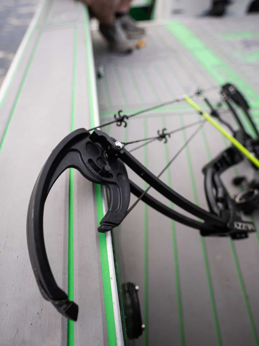 1. Compound bow sight and accessories on a shooting table for archery practice.