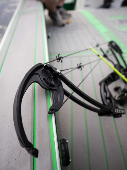 1. Compound bow sight and accessories on a shooting table for archery practice.