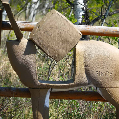 Camouflage ground blind with deer silhouette and arrow for bowhunting, set against natural outdoor foliage.