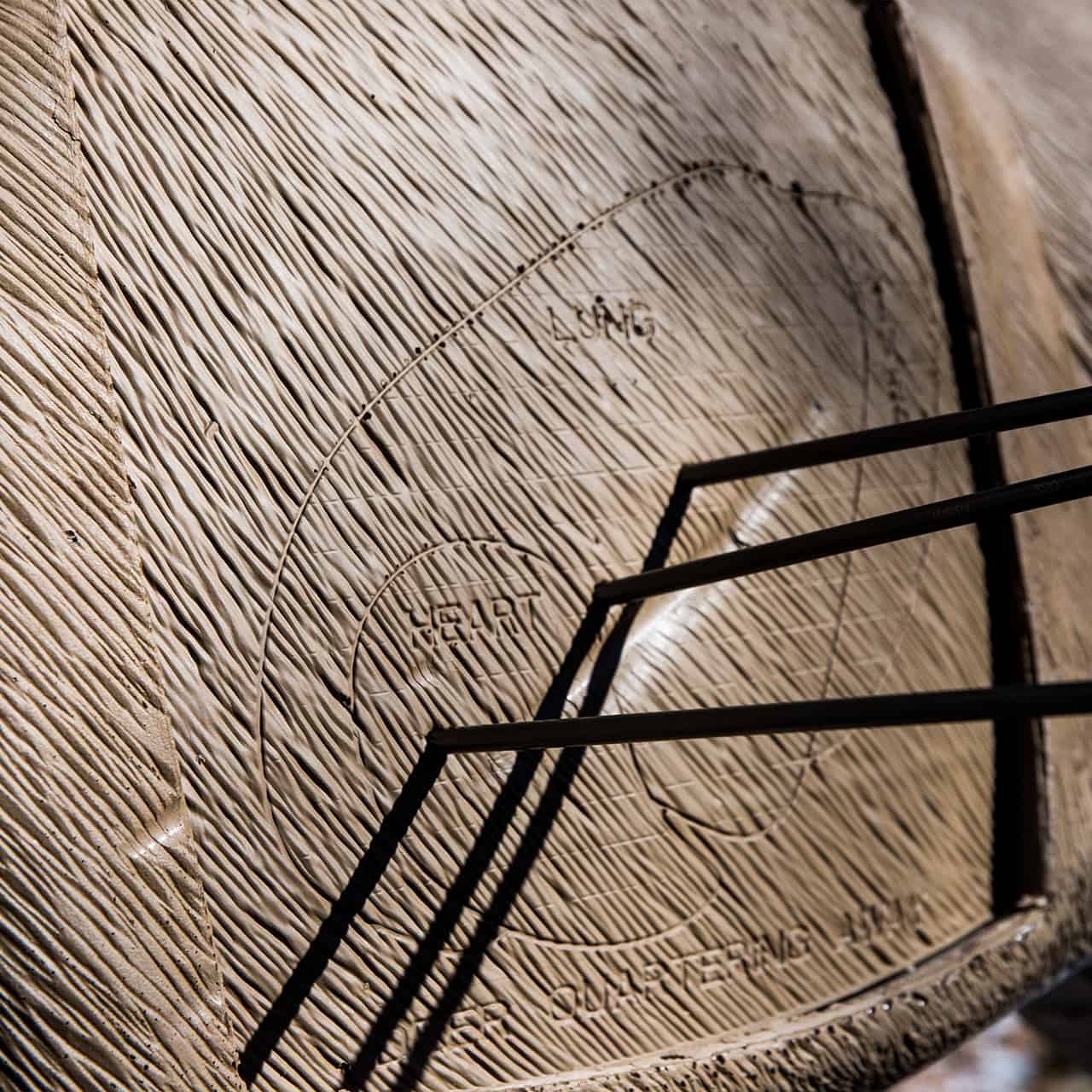 Aiming target on wooden archery target for bowhunting practice, with metal stand.