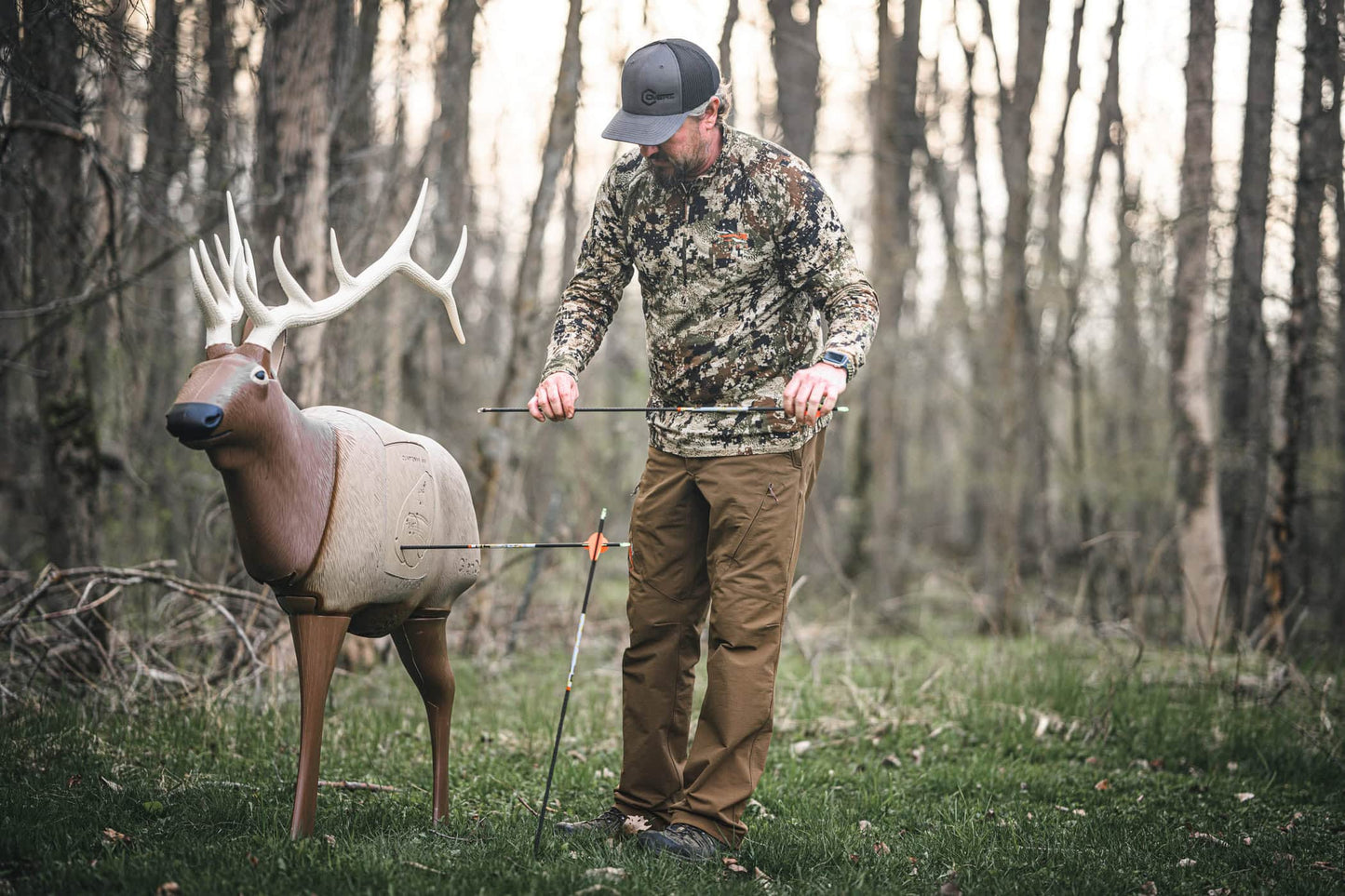 Deer target with archery arrow shot outdoors in wooded area during hunting season.