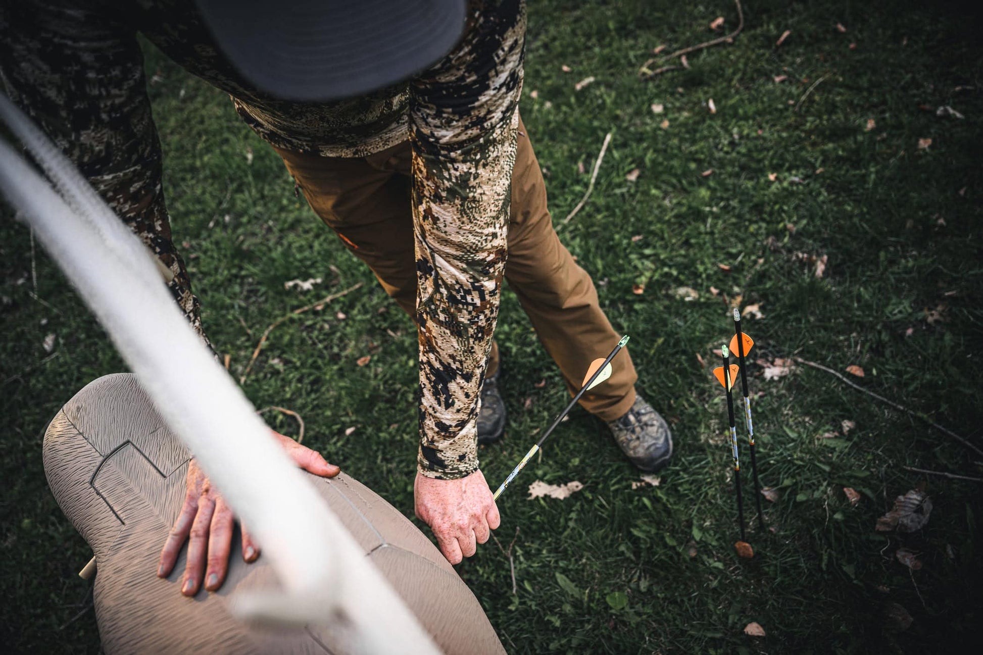 Archer’s setup in a ground blind with arrows on the ground, preparing for bowhunting.