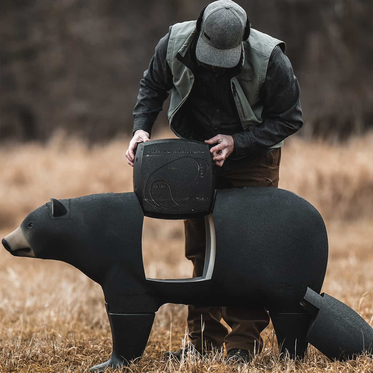 Portable game call device in outdoor field with bowhunting animal decoy.