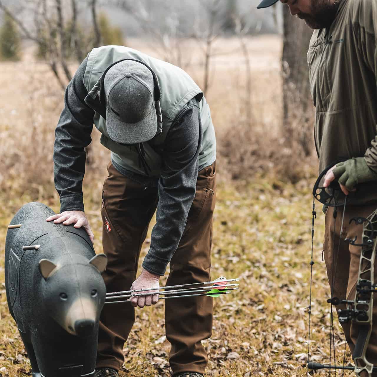 Archery hunters preparing for a hunt with bow and gear in a fall forest setting.