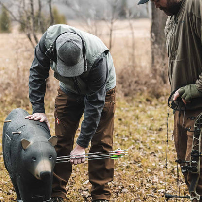 Archery hunters preparing for a hunt with bow and gear in a fall forest setting.