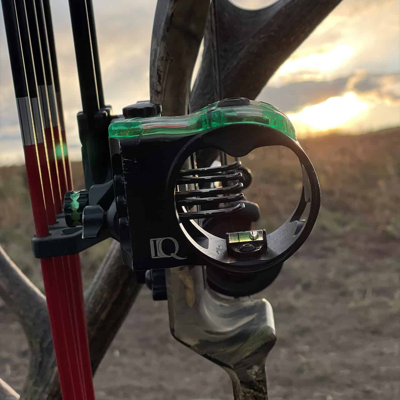 Precision archery sight with bubble level at sunset.