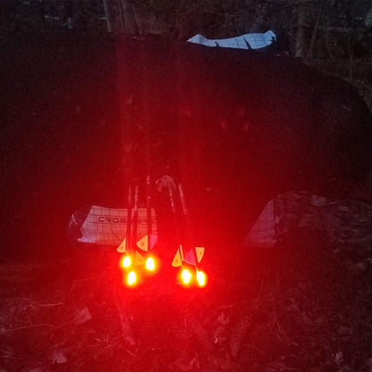 Reflective safety lights attached to a backpack for outdoor visibility at night.