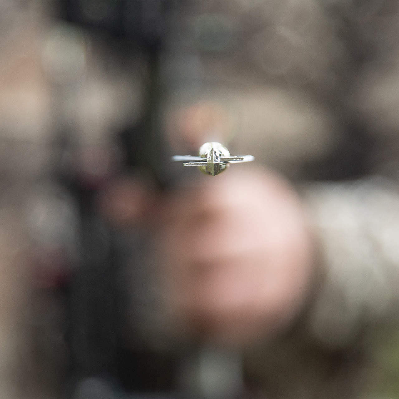 Miniature airplane toy flying outdoors, blurred background.