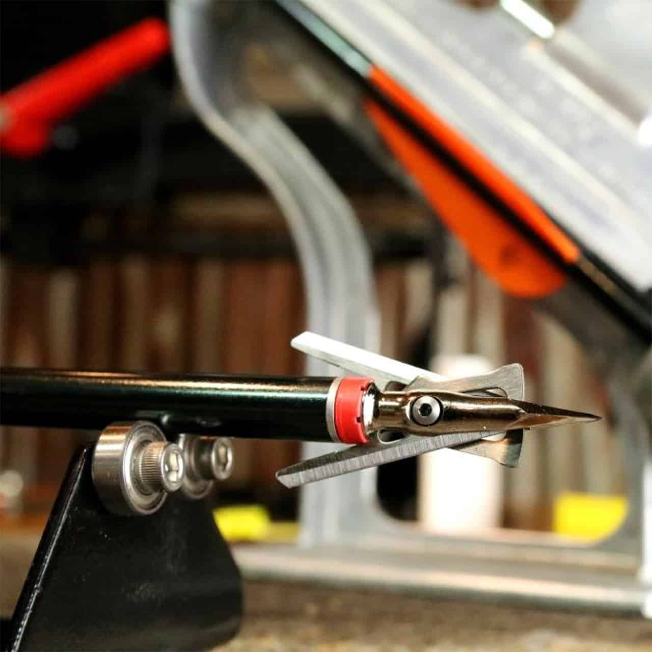 Precision arrow nock and launcher on a bow press, ready for archery setup and tuning.