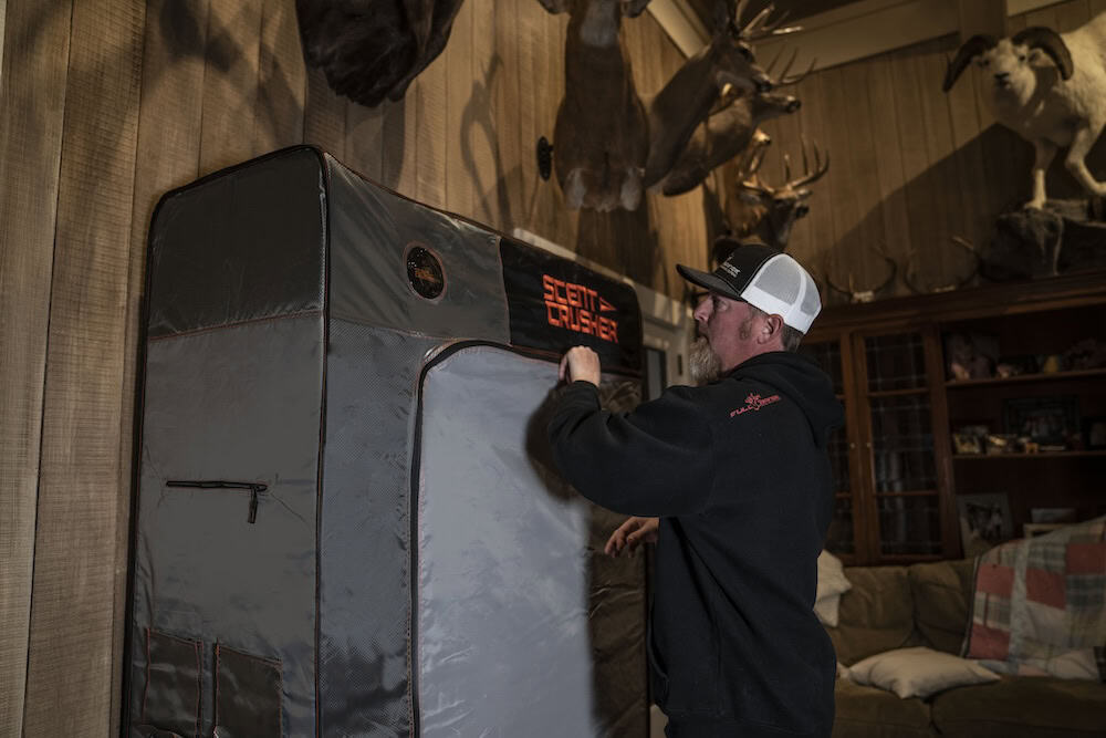 Portable archery target in a rustic room with mounted deer and other game heads.