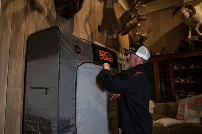 Portable archery target in a rustic room with mounted deer and other game heads.