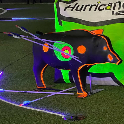 Bright neon archery target shaped like a bear with illuminated markings and arrows on a dark field.
