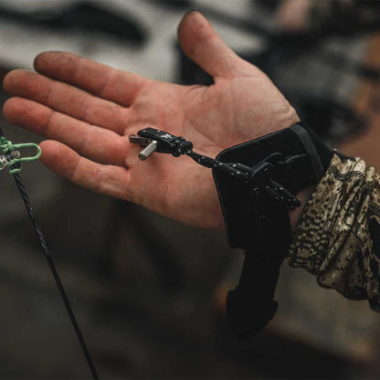 1. Lightweight archery release aid attached to a hunter’s hand for precise shooting.