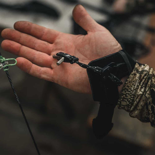 1. Lightweight archery release aid attached to a hunter’s hand for precise shooting.
