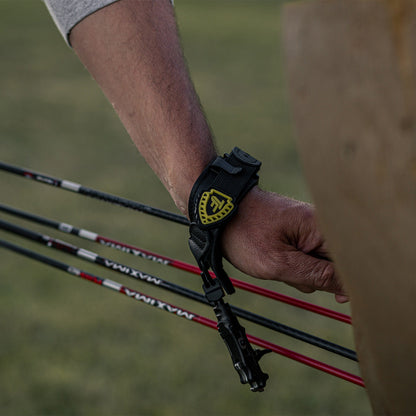 1. Black archery arm guard with yellow logo on wrist, outdoor hunting gear accessory.