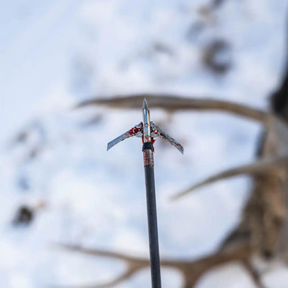 AEA Bloodsport arrow stuck in snow, symbolizing precision in bowhunting.