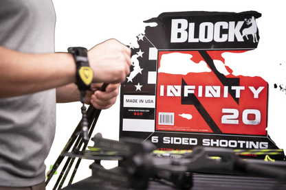 1. person adjusting a bow sight at an archery shooting range outdoors.