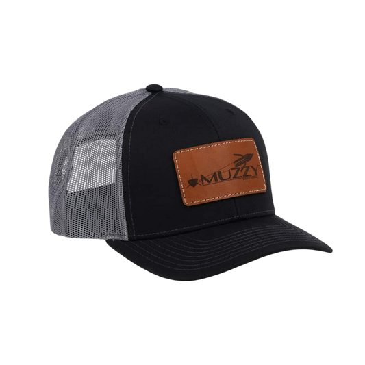 Stylish black and gray trucker cap with a brown leather patch featuring Muzzy logo.