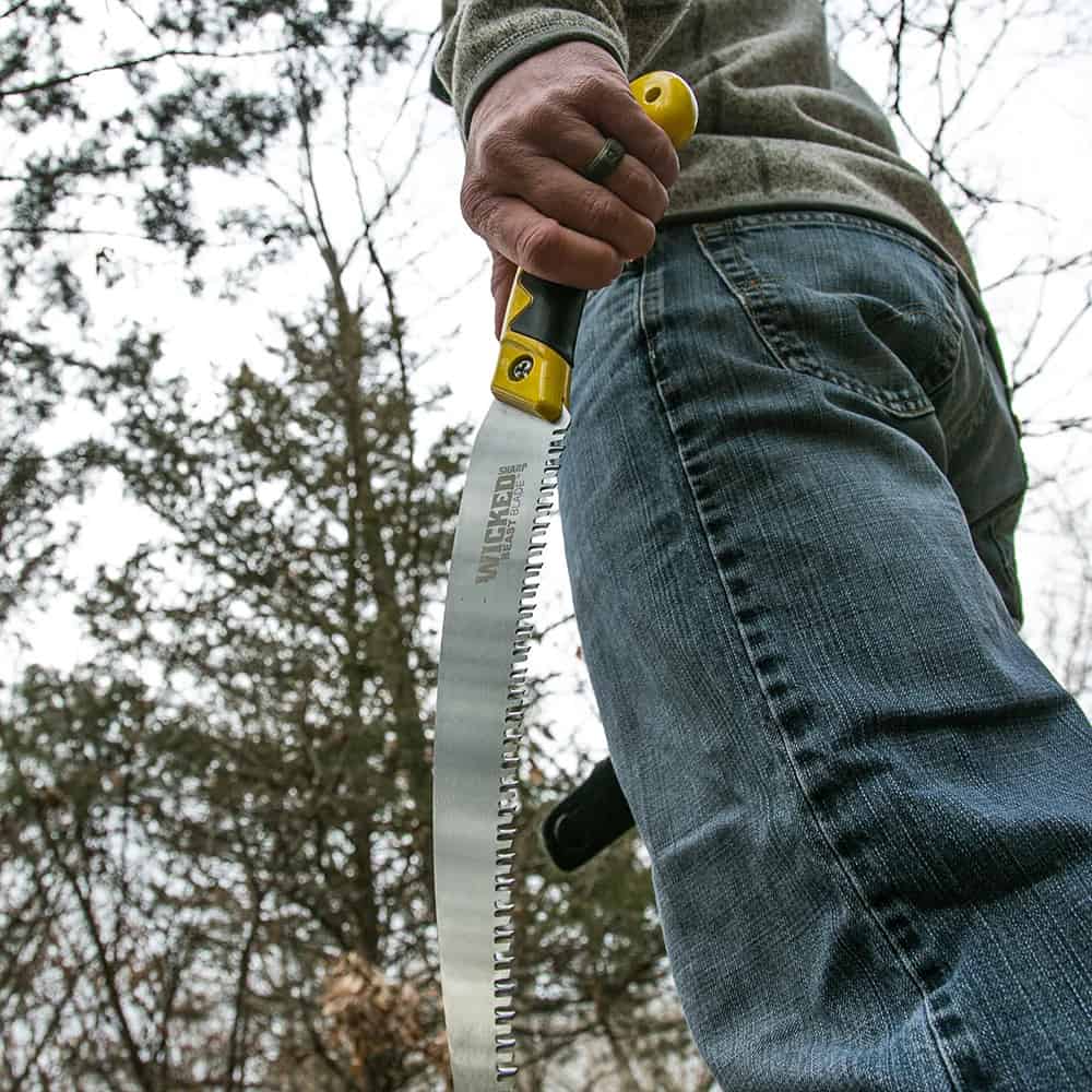 Heavy-duty hand saw for outdoor woodcutting with a yellow-handled grip.