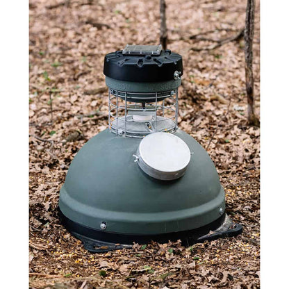 Robotic deer attractant trap in outdoor woodland setting for hunting and wildlife observation.