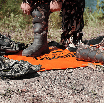 Durable camo hunting boots on outdoor terrain with archery gear and gear mat.